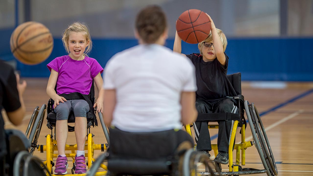 CHILDREN PLAYING WHEELCHAIR BASKETBALL CHILDREN PLAYING WHEELCHAIR BASKETBALL